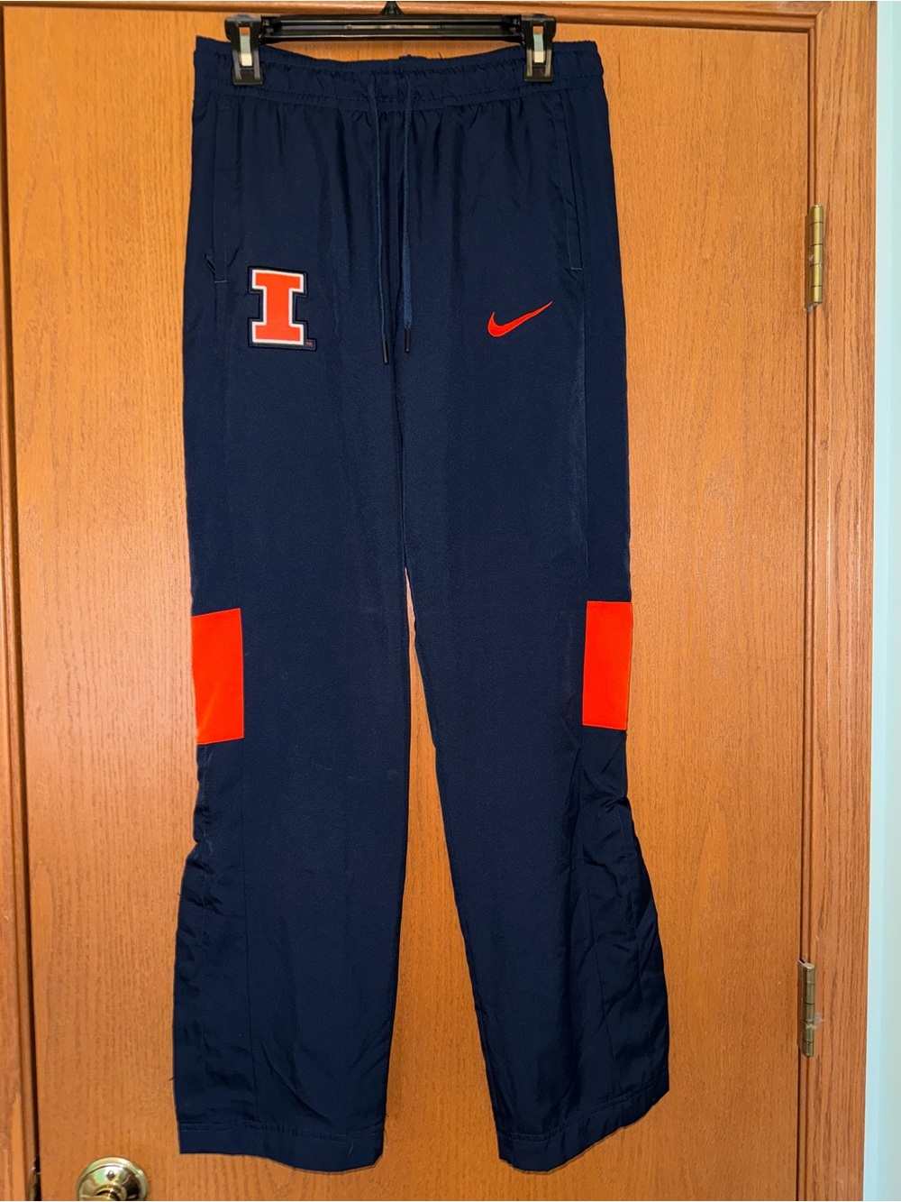 Nike Navy Athletic Pants with Orange Accents and 'I' Patch